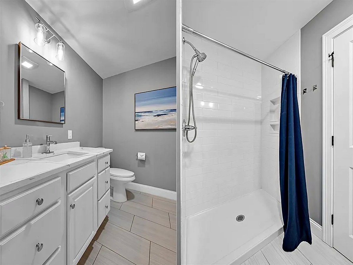 Bathroom with plank tile flooring and a tiled shower surround